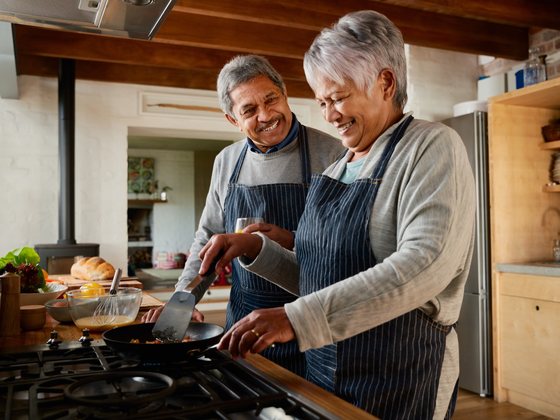 An older couple preparing a fresh meal together in their kitchen.